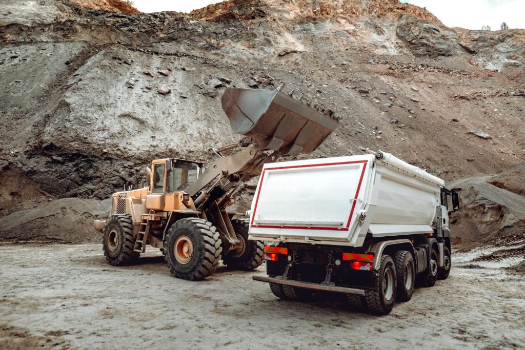 Digger unloading into truck in a mining quarry