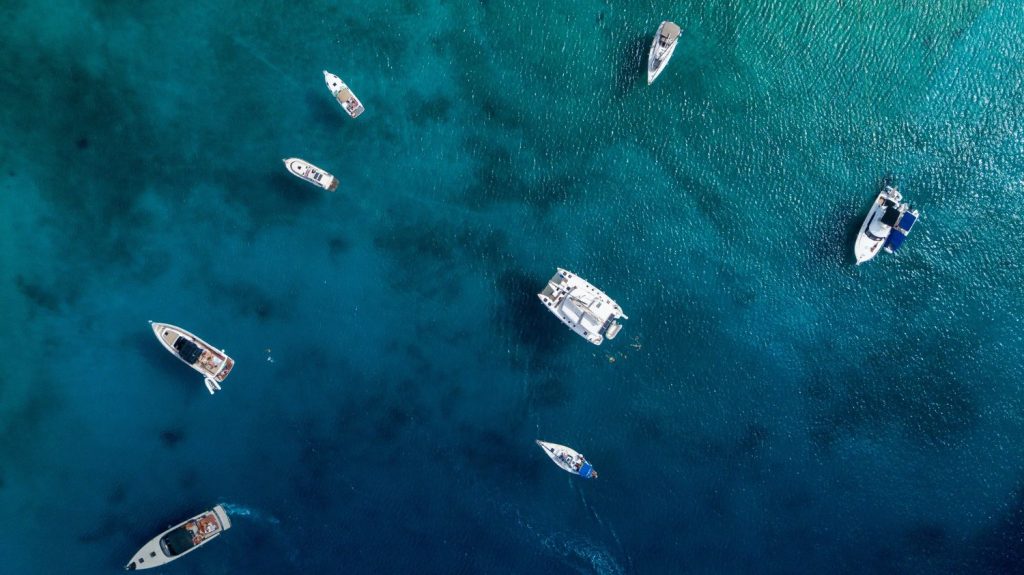 Aerial photo of small boats in the sea to illustrate performance monitoring for maritime and connectivity at sea