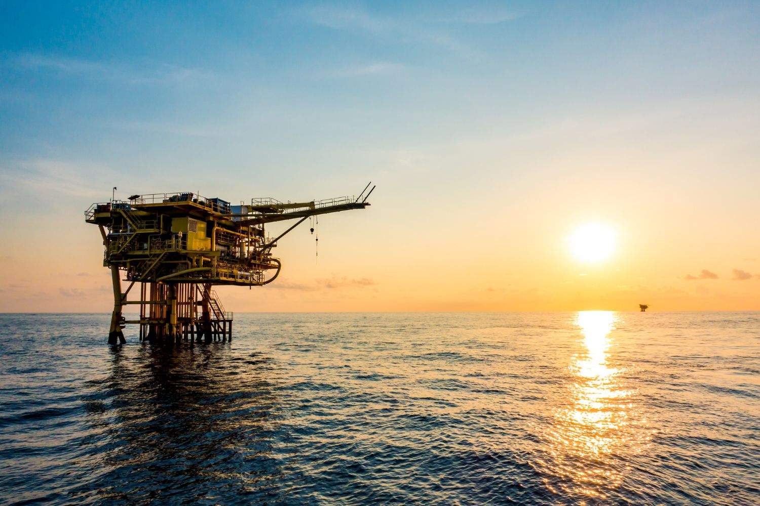 Photo of an oil rig as the sun sets to illustrate a case study on L-Band services for HGIS in Malaysia