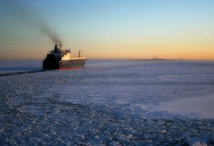Barco atravesando el hielo para ilustrar cómo la tecnología por satélite puede reducir las emisiones del transporte marítimo.