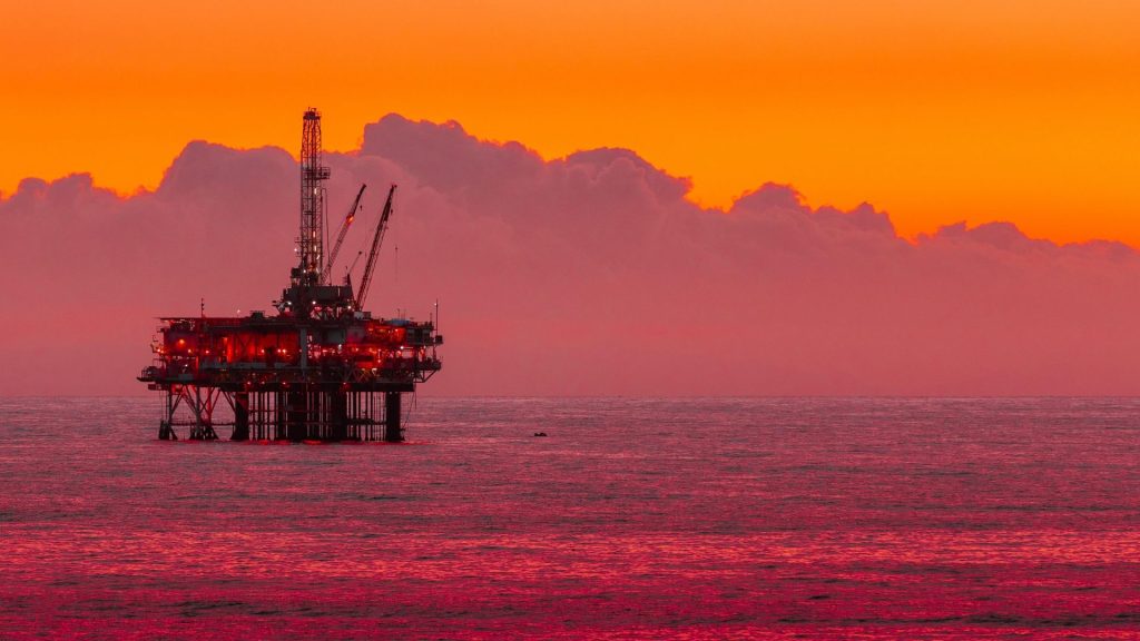 Oil rig at sunset to illustrate secure data management solutions for subsea