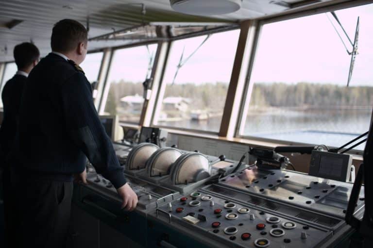 Capitán y miembro de la tripulación mirando desde el puente del barco