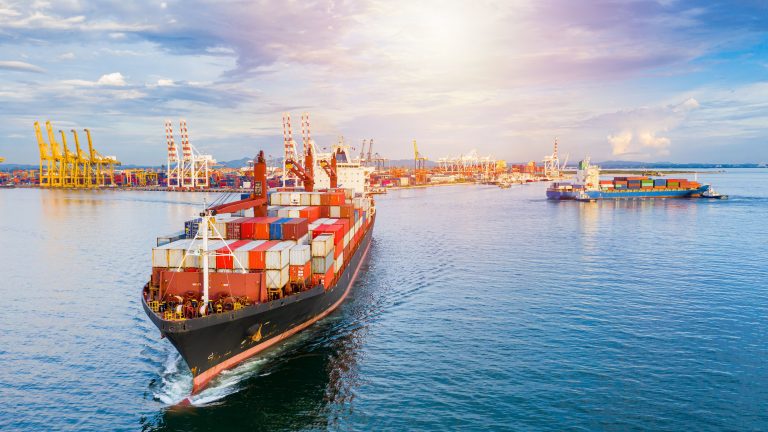 Portacontenedores cerca de los muelles para ilustrar el Internet de las Cosas para el sector marítimo