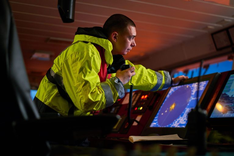 Man at a ship's bridge in high vis jacket